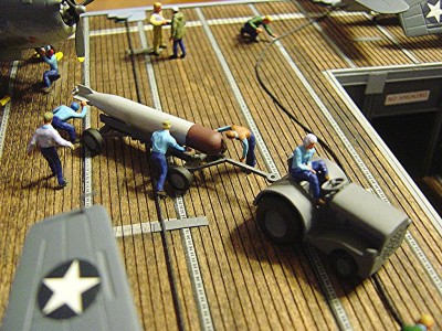Torpedo being readied for loading into a TBF. Note the deck tractor.