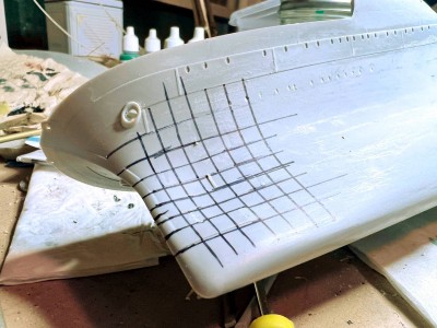 The lines running the length of the hull curve inwards at the dent, before curving back outwards aft of the dent.