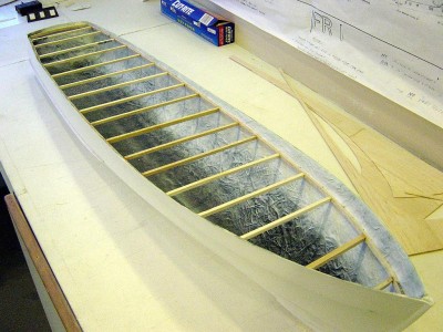 DSC03745.JPG (172.78 KiB) Viewed 20029 times The first order of business with this was to sand it out smooth. I then had to plot out where the deck would go. There is a line molded in the hull that shows the break between the hull and the bulwark, but it does not go all the way aft. I drew lines on the outside of the hull where the deck should be, then drilled small holes that would be visible on the inside of the hull after a coat of white primer. I then added the framework you see, plotting along the small holes already drilled. 1/4" balsa stick used here. Frame work is flat right now, I will add the camber before I secure the deck to the hull.