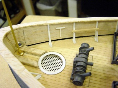 A close up here of the bow area. Small T is a scuttle plate wrench, to the right of that is the winch handle, they were manually operated. Also added hawse lips and skid plates for anchor lines. Forward jackstaff is turned brass. Scuttle grating is perforated aluminum.