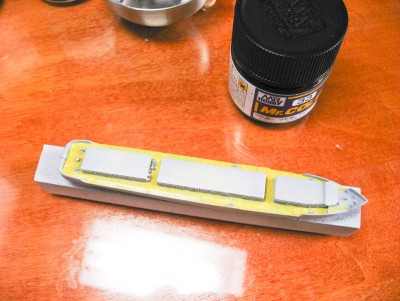 I primed the entire model with Mr. Surfacer 1200 primer.  This is very close to the deck color, so I masked off the decks.  This is about 2 hours of work, with many many breaks during the process to uncross my eyes.