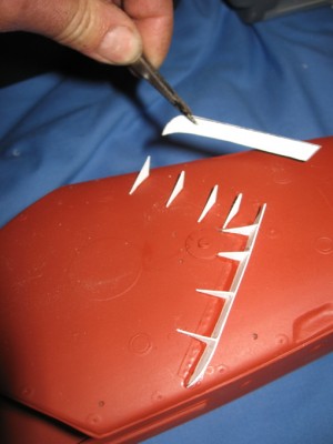 Fitting the fore deck breakwater. The location marks and rivet detail are already moulded into the GRP fore deck.