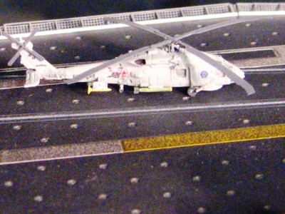 A couple of seahawks are prepping for takeoff fore of the waist cats, armed for a sub-hunting patrol.