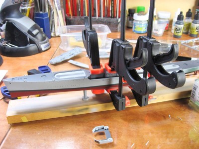 The midship's deckhouse is the one major problem spot on these kits. It doesn't fit very well in bare styrene, and when you paint it, the fit is even worse. It's a simple fix, though: sand down the forward bulkhead until you can wedge it into place, then apply ample adhesive, and clamp it down like it's a fugitive flight risk.