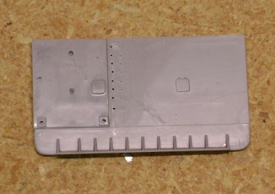 Revell chose to mold the fantail bulkhead in two pieces; the portion around the stern anchor stand is a separate piece. Although Revell didn't announce it at the time of their release of the early LSM, they planned to release both an early and a late LSM. The stern anchor stand was changed on later LSMs, necessitating a way to incorporate this difference in the two kits.  Here's the two pieces assembled.  I've also filed down the ladder rungs and drilled new holes for brass wire.